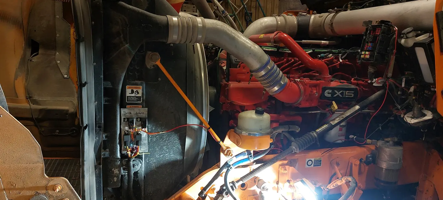 Un moteur Cummins X15 éclairé par une baladeuse pendant un diagnostic