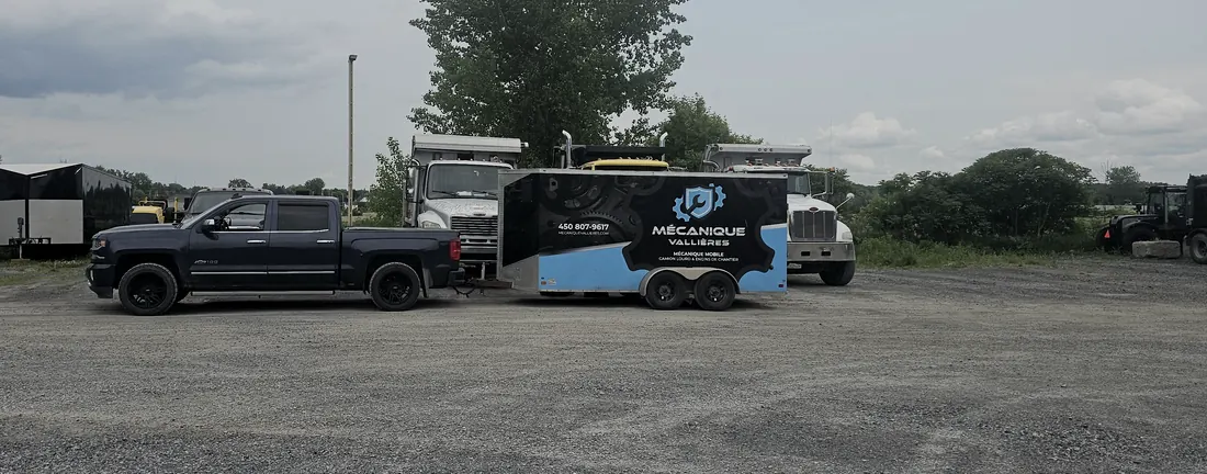 La camionnette et la remorque-atelier de Groupe Mécanique Vallières, devant des camions à benne