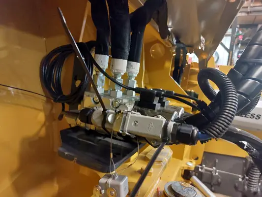 Un distributeur hydraulique et ses boyaux sur une machine jaune